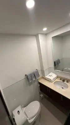 a bathroom with a toilet and a sink and a mirror at Apartamento con salida y vista a la playa in Cartagena de Indias