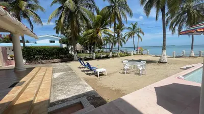 a patio with a table and chairs on the beach at Casa frente a la playa, San Antero Cordoba in San Antero