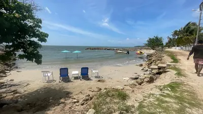 a beach with chairs and umbrellas on the sand at Casa frente a la playa, San Antero Cordoba in San Antero
