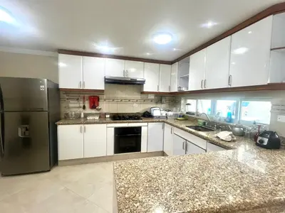 a kitchen with white cabinets and a stainless steel refrigerator at Private House - 4 Pisos - 100 Mts de la playa in Cartagena de Indias