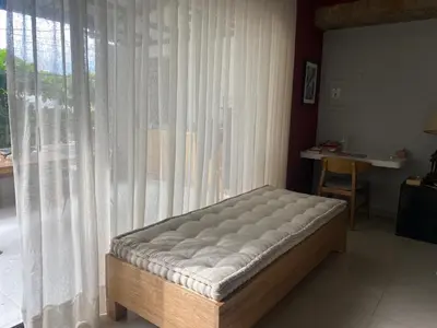 a bed sitting in a room next to a window at Apartamento Loft in Cartagena de Indias