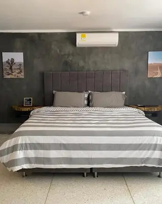 a bedroom with a large bed with a striped blanket at Casa Piedra Barranquilla in Barranquilla