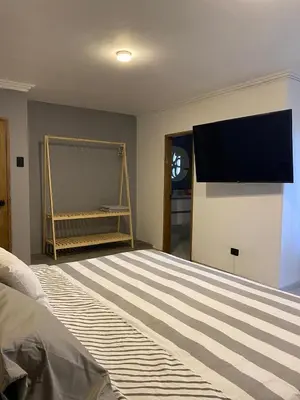 a bedroom with a bed with a tv on the wall at Casa Piedra Barranquilla in Barranquilla