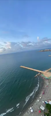 an airplane wing flying over the ocean and a beach at Palmetto Eliptic in Cartagena de Indias