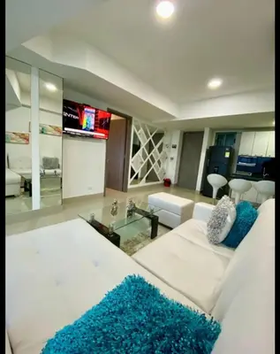 a living room with a white couch and a tv at Palmetto Eliptic in Cartagena de Indias