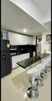 a kitchen with black and white appliances and bar stools at Palmetto Eliptic in Cartagena de Indias