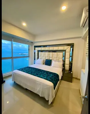 a bedroom with a large bed with a large window at Palmetto Eliptic in Cartagena de Indias