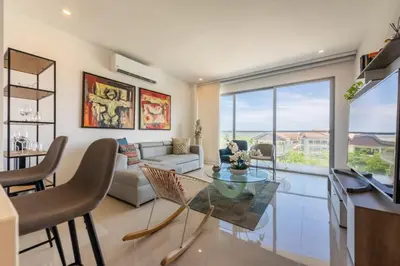 a living room with a glass table and chairs at Frente al Mar, con playa y 4 piscinas en Cartagena in Cartagena de Indias