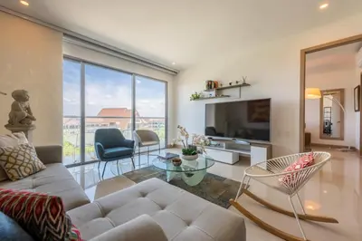 a living room with a couch and a large window at Frente al Mar, con playa y 4 piscinas en Cartagena in Cartagena de Indias