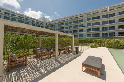 a patio with benches and a large building at Frente al Mar, con playa y 4 piscinas en Cartagena in Cartagena de Indias