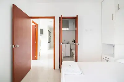 a white room with a bed and a bathroom at Apto Torre Primi Cerca a la Playa, Aeropuerto y al Centro in Cartagena de Indias
