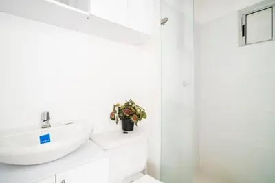 a white bathroom with a sink and a shower at Apto Torre Primi Cerca a la Playa, Aeropuerto y al Centro in Cartagena de Indias