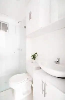 a white bathroom with a toilet and a sink at Apto Torre Primi Cerca a la Playa, Aeropuerto y al Centro in Cartagena de Indias