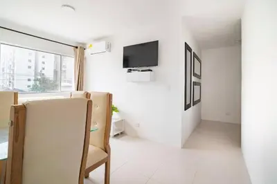 a white room with chairs and a tv on a wall at Apto Torre Primi Cerca a la Playa, Aeropuerto y al Centro in Cartagena de Indias