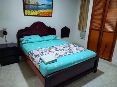 a bedroom with a bed with a blue comforter at Hotel Tamaulipas Mixteca in Sincelejo