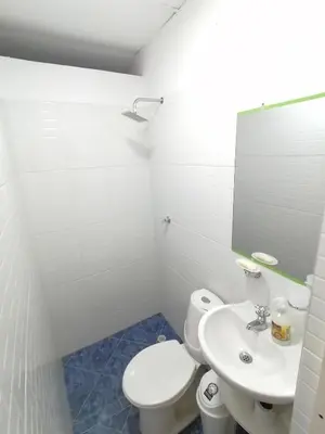 a white bathroom with a toilet and a sink at Casa Esmeralda in Cartagena de Indias