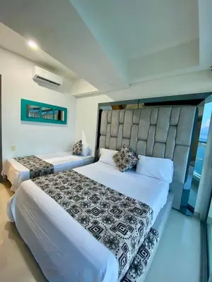 a bedroom with two beds and a large headboard at Palmetto elíptic apto 3302 vista al mar in Cartagena de Indias