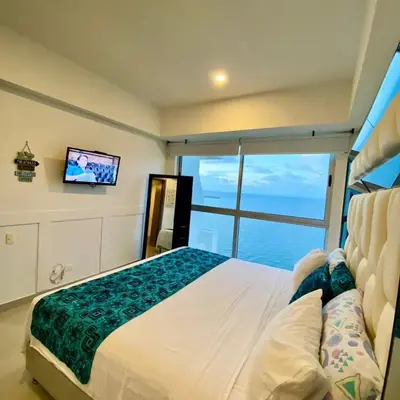 a bedroom with a large bed and a tv at Palmetto elíptic apto 3302 vista al mar in Cartagena de Indias