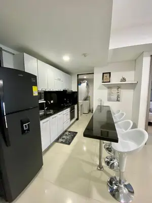 a kitchen with a black refrigerator and white cabinets at Palmetto elíptic apto 3302 vista al mar in Cartagena de Indias