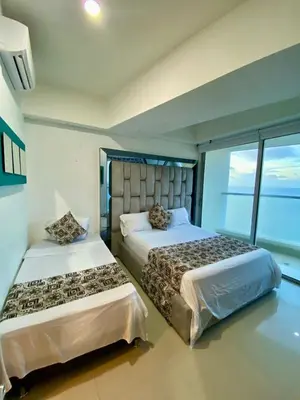 a bedroom with two beds and a large window at Palmetto elíptic apto 3302 vista al mar in Cartagena de Indias