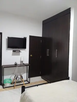 a bedroom with a large black cabinet and a desk at Casa de Huesped Sky Blue Barranquilla Colombia in Ciudad Jardín
