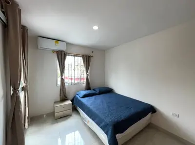 a bedroom with a bed with a blue blanket and a window at Espectacular casa con parqueadero bien ubicada in Barranquilla