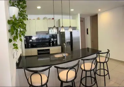 a kitchen with a black counter with stools in it at Cartagena Espectacular apartamento en bocagrande in Cartagena de Indias