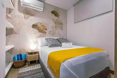 a bedroom with a bed with a yellow and white blanket at Beachfront Condo 1605 Murano Centro 1, Near Walled City Airport Pick Up in Cartagena de Indias