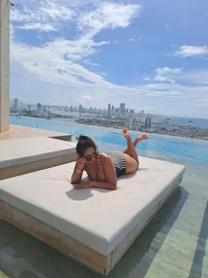 a woman laying on a mattress next to a pool at Beachfront Condo 1605 Murano Centro 1, Near Walled City Airport Pick Up in Cartagena de Indias