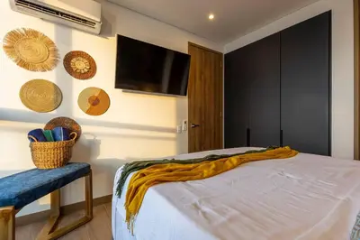 a bedroom with a bed and a flat screen tv at Beachfront Condo 1605 Murano Centro 1, Near Walled City Airport Pick Up in Cartagena de Indias