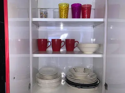 a cabinet filled with plates and cups and bowls at Moderno hospedaje privado con piscina in Cartagena de Indias
