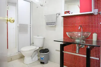 a bathroom with a toilet and a sink and red tiles at Moderno hospedaje privado con piscina in Cartagena de Indias