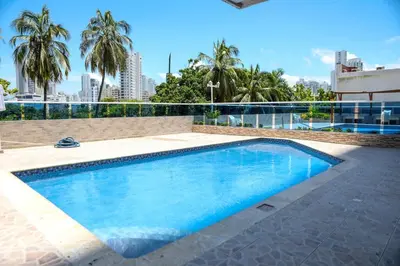 a swimming pool with blue water and palm trees at Moderno hospedaje privado con piscina in Cartagena de Indias