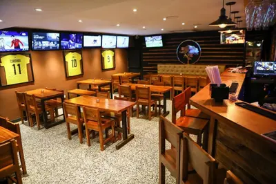 a restaurant with wooden tables and chairs and televisions at Moderno hospedaje privado con piscina in Cartagena de Indias