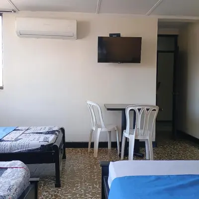 a room with a table and two chairs and a flat screen tv at Hotel Villa Giron inn in Barranquilla