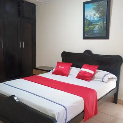 a bedroom with a large bed with red pillows at Hotel Villa Giron inn in Barranquilla