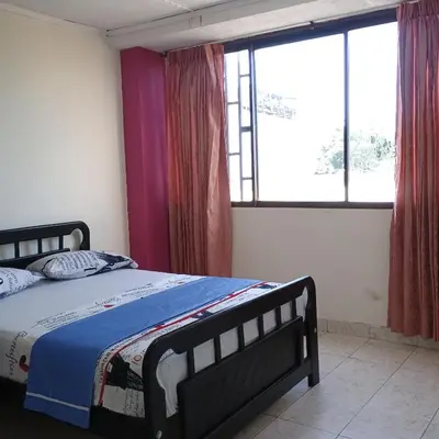 a bedroom with a bed and a large window at Hotel Villa Giron inn in Barranquilla