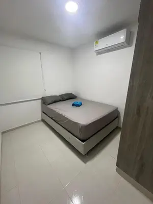 a small bedroom with a bed in a white room at Bello apartamento con visita al mar in Cartagena de Indias