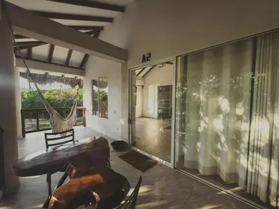a living room with a hammock and a table at SABAI Beach Hotel in Baru