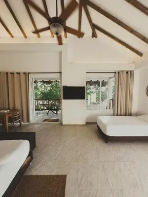 a bedroom with two beds and a ceiling at SABAI Beach Hotel in Baru
