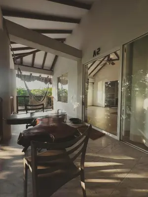 a room with a table and chairs and a hammock at SABAI Beach Hotel in Baru