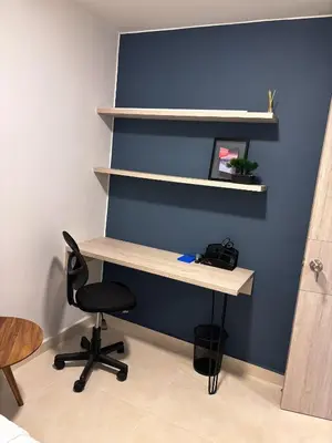 an office with a desk with a chair and shelves at Apartamento La Plazuela Barranquilla in Barranquilla