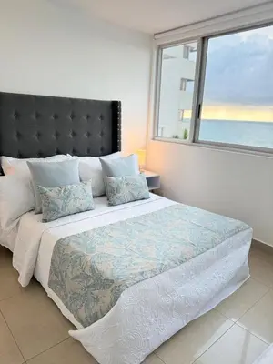 a bedroom with a large bed with a large window at Alojamiento Cartagena frente Al Mar in Cartagena de Indias