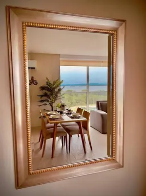 a mirror reflecting a table and chairs in a living room at Martinique Apto Private Jacuzzi - Netflix-Disney-Prime in Cartagena de Indias