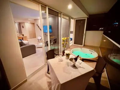 a bathroom with a tub and a table and a room at Martinique Apto Private Jacuzzi - Netflix-Disney-Prime in Cartagena de Indias