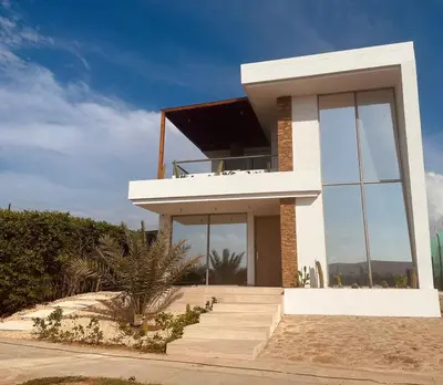 a house with a balcony on the beach at Casa frente a la playa in Salina de Rey