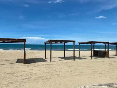 a group of umbrellas on a sandy beach at Casa frente a la playa in Salina de Rey