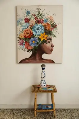 a vase on a table with a painting on the wall at MANGO BiCHE - HOUSE in Cartagena de Indias