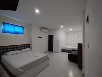 a white room with two beds and a couch at Postel bar hotel in Cartagena de Indias