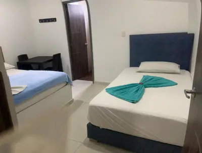 a hotel room with two beds and a table at Postel bar hotel in Cartagena de Indias